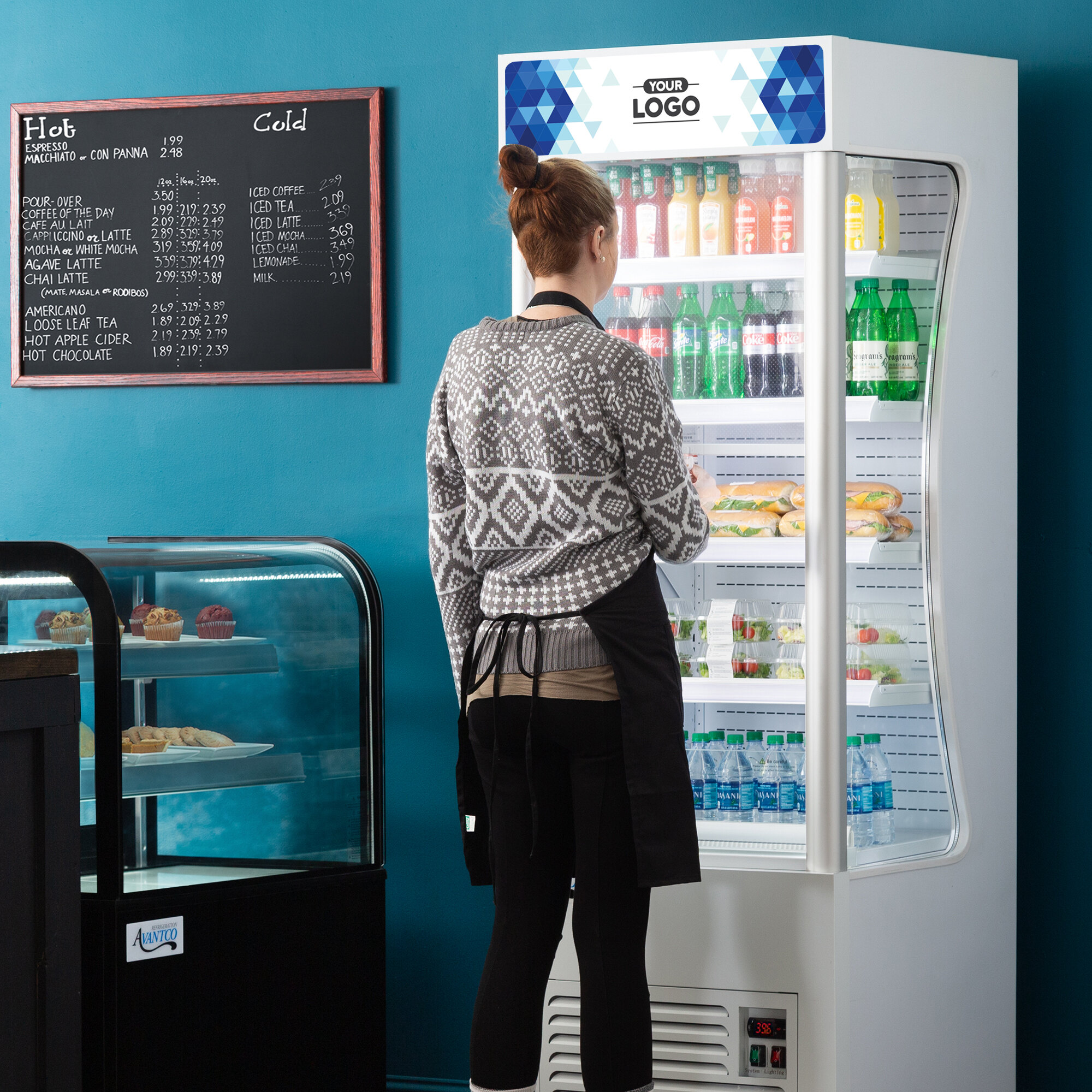 A woman standing in front of a white Avantco refrigerated air curtain merchandiser.