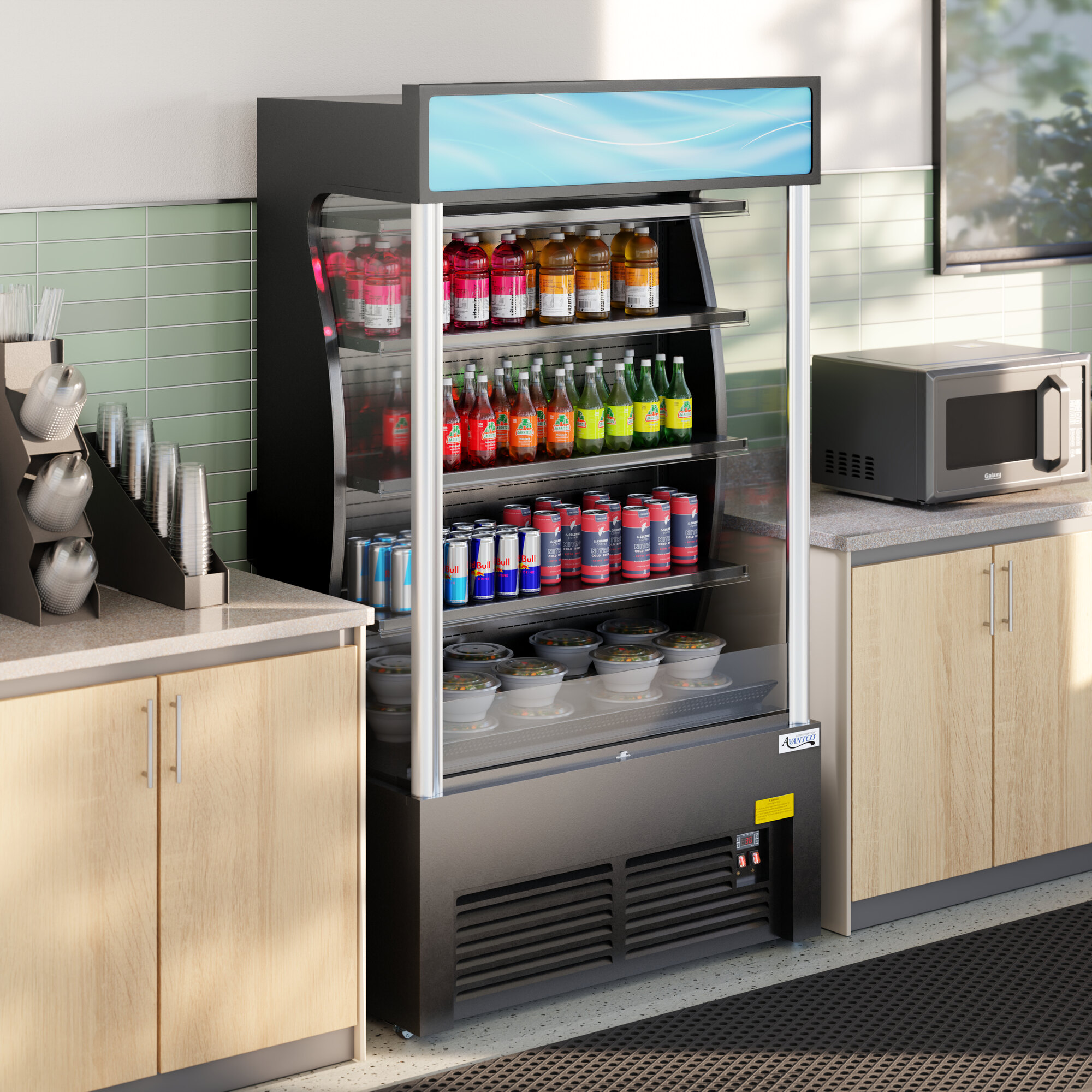 A black refrigerated air curtain merchandiser stocked with drinks and food containers, situated between two countertops in a commercial setting.