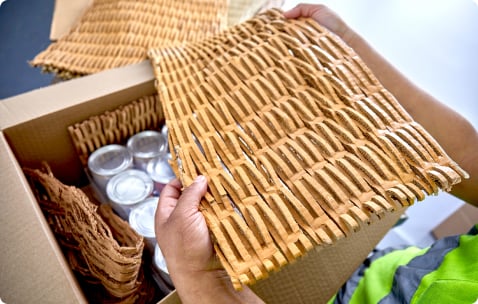 employee packing box with shredded cardboard corrugate