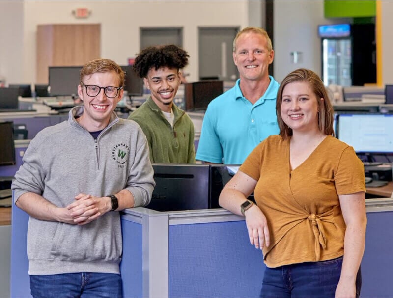 office workers standing around a desk