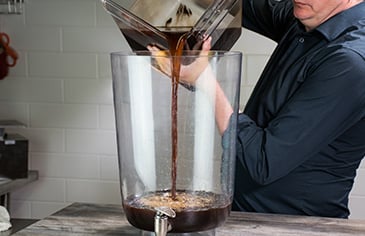 pouring cold brew coffee into a beverage dispenser