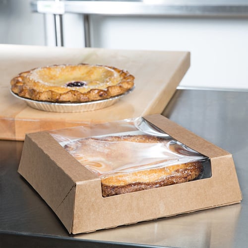 apple pie in a cardboard box with transparent plastic lid