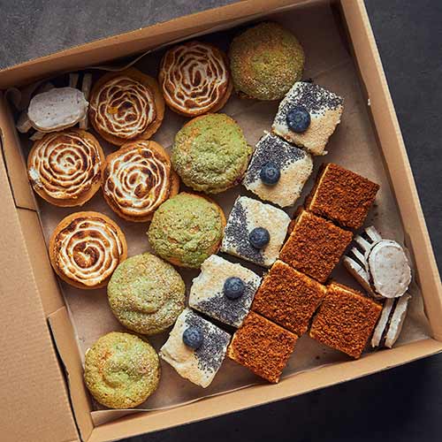 cardboard box full of a variety of french desserts