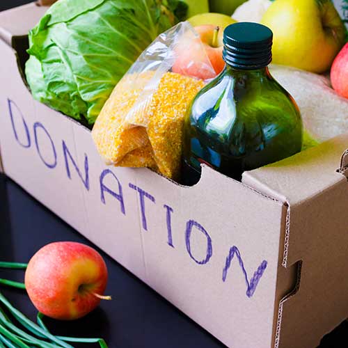 cardboard donation box filled with fresh produce olive oil rice and cornmeal
