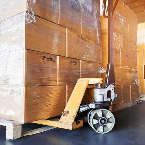 close up of hand pallet truck with stacks of packages and boxes on pallets