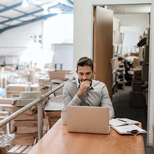 manager working online while sitting in a warehouse office
