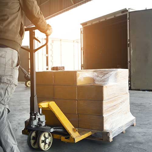 worker loading packages and boxes into cargo container at dock warehouse