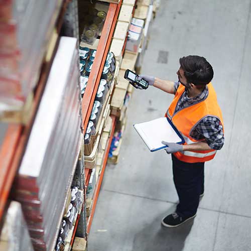 worker with scanner reviewing goods in warehouse