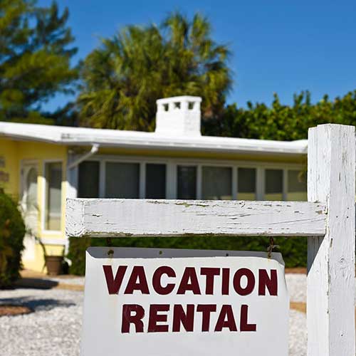 house with a vacation rental sign on the outside