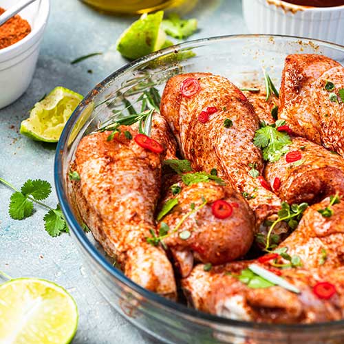 raw chicken drumstick legs marinating in herbs and hotgloj spices
