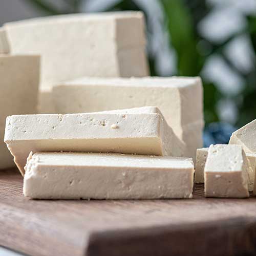 fresh tofu diced on a cutting board