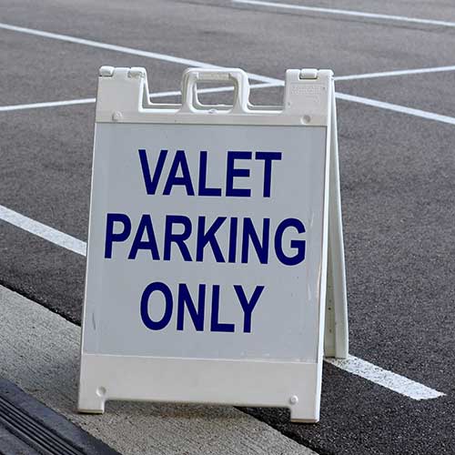 white and blue valet parking sign in the parking lot