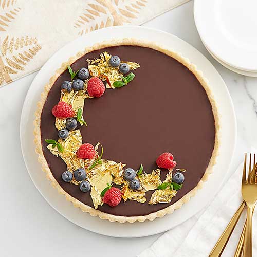edible gold on chocolate pie topped with fruit