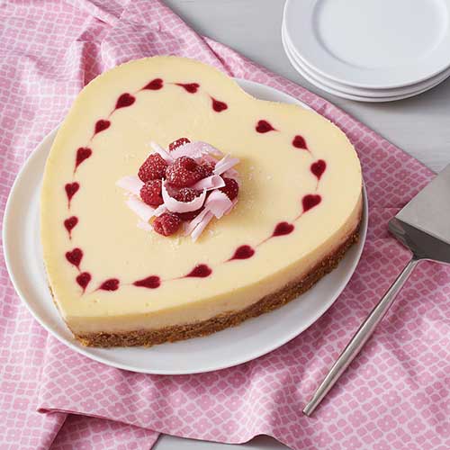 heart shaped cheesecake topped with raspberries