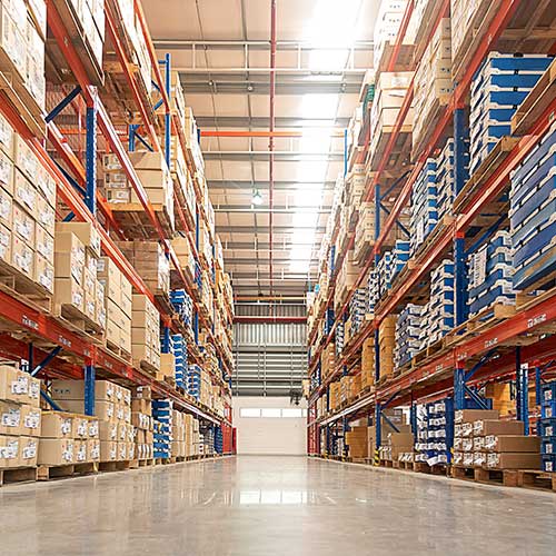 rows of shelves with goods boxes in large distribution warehouse at industrial storage factory