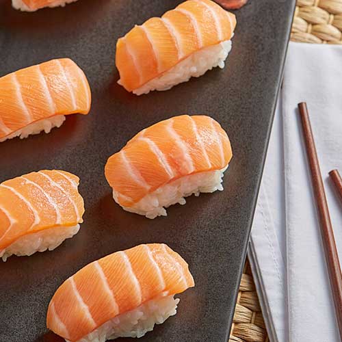 salmon sushi rolls on black platter