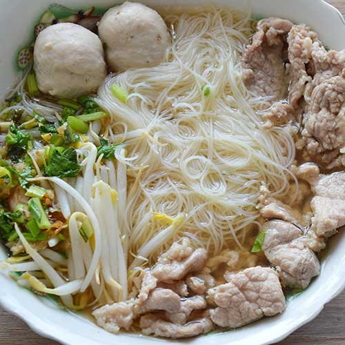 vermicelli in white ceramic bowl on wooden table