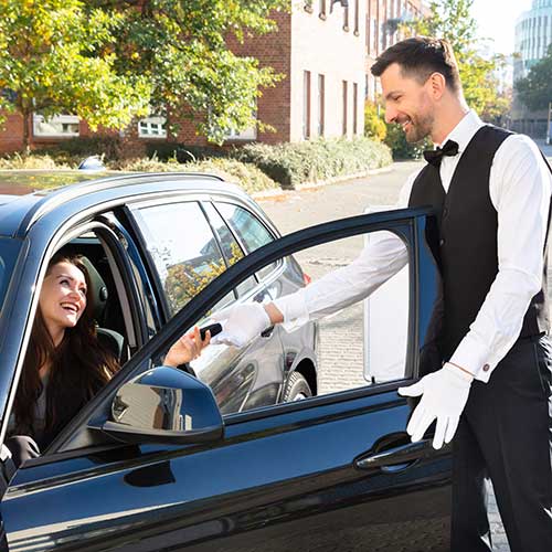 woman giving car key to valet