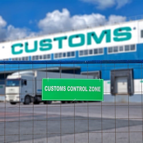 A customs sign displayed on a fence in front of a bonded warehouse