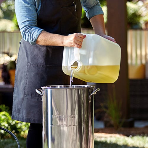 Man pouring peanut oil into a turkey fryer