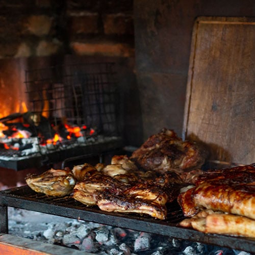 Cuts of beef and ribs grilling over coal fire on an argentinian bbq grill