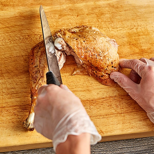 man lifting turkey covered in seasoning