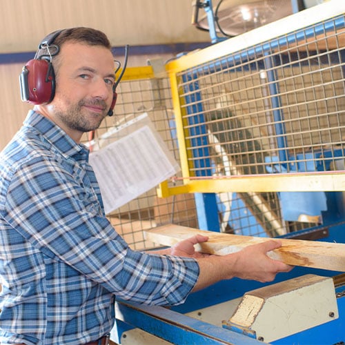 woodworker operating a machine with a safety fence
