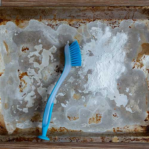 cleaning the pan with a cleaning agent and a brush