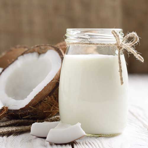 mason jar of milk or yogurt on hemp napkin on white wooden table