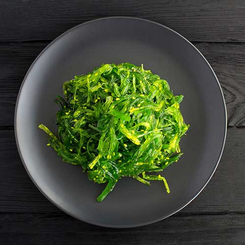 salad with seaweed and sesame on a gray plate