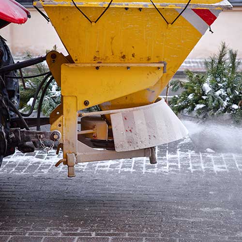 snow plow on pedestrian street salting and cleaning road