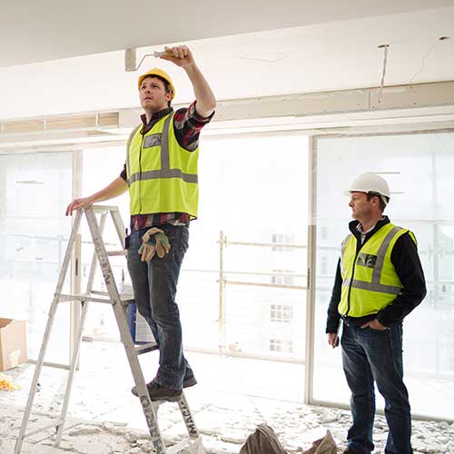 construction worker on ladder at construction site