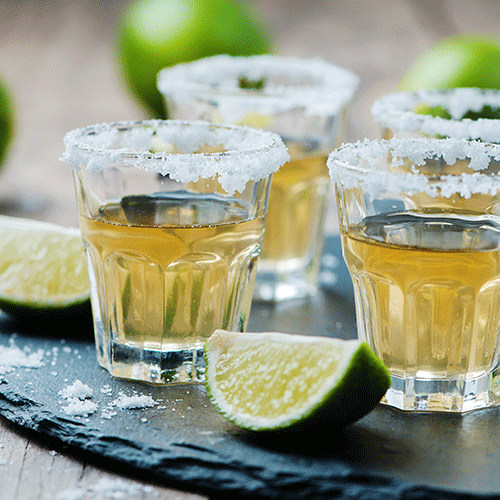 gold tequila in shot glasses rimmed with salt