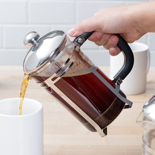 pouring coffee from french press into white mug