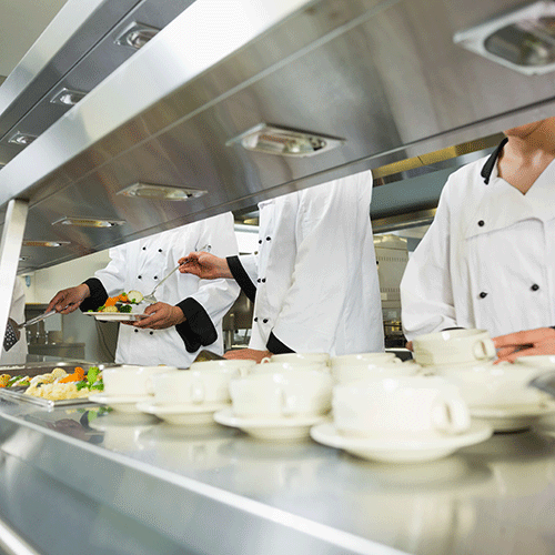 four cooks in commercial kitchen