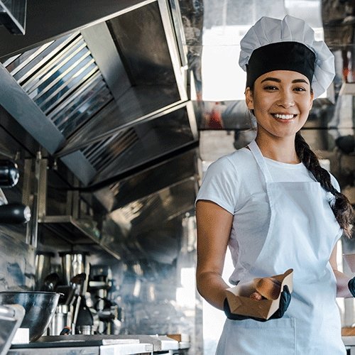 happy woman chef holding carton plates in a food truck