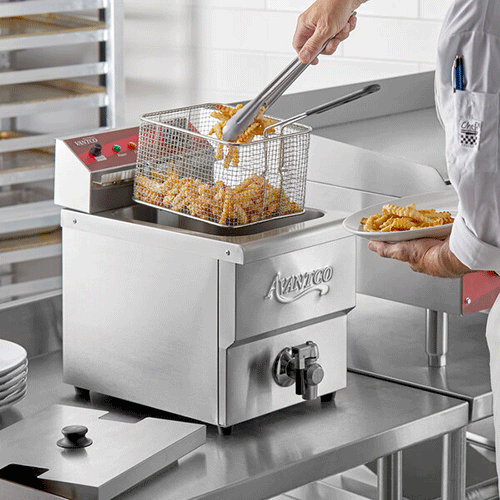 person taking fries out of deep fryer