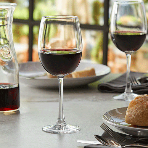 red wine in stemmed glass on a grey table with bread