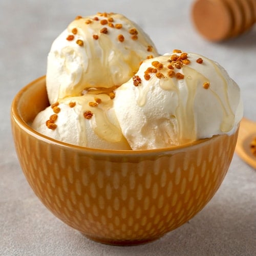 tasty ice cream with bee pollen and honey in bowl on table