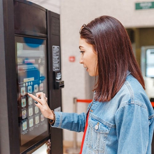 woman using a touch screen coffee vending machine