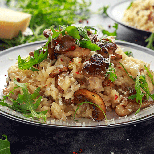 Italian mushroom risotto with parmesan cheese and arugula on top