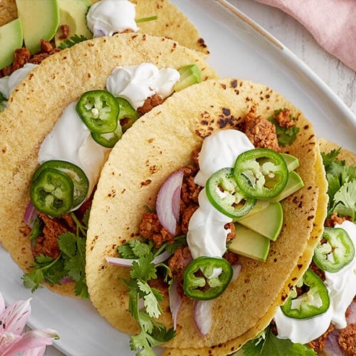 corn tortilla tacos with sour cream and jalapenos