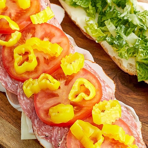 pickled peppers and tomatoes on an italian sandwich