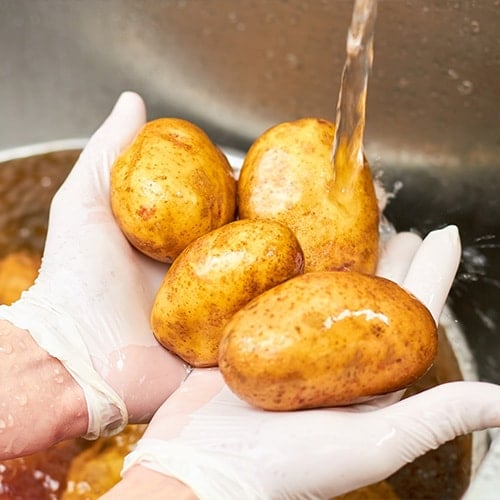 washing potatoes in a sink