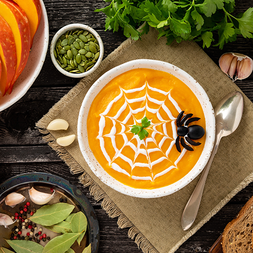 butternut squash soup with a white spider web shaped drizzle