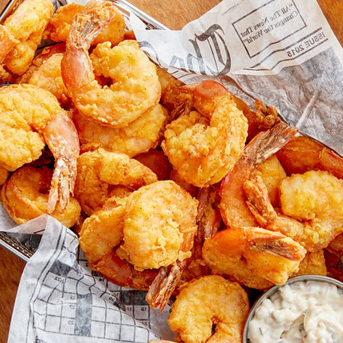 Fried shrimp nestled in a newspaper lined basket