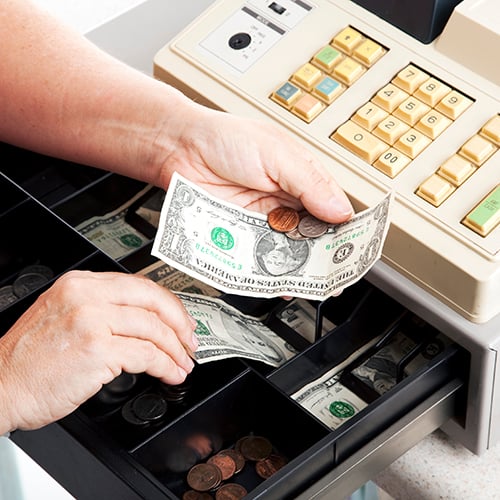 hands pulling cash out of register