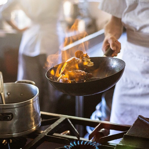 line cook making dish on a gas stove