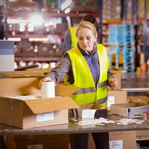 worker loading a box at packing station