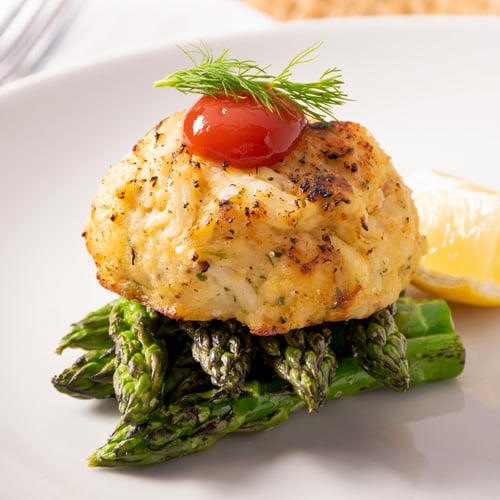 Peekytoe Crab cake served on top of asparagus